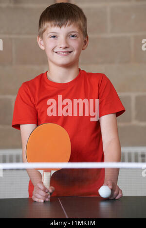 Portrait Of Boy Playing Table Tennis In School Gym Stock Photo