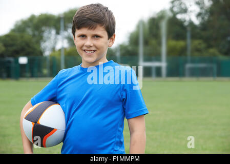 Portrait Of Boy Holding Ball On School Rugby Pitch Stock Photo