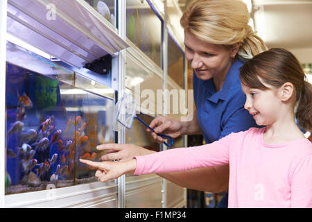 Girl With Sales Assistant Choosing Goldfish In Pet Store Stock Photo