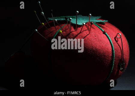 Strawberry pincushion resting on a dark background Stock Photo