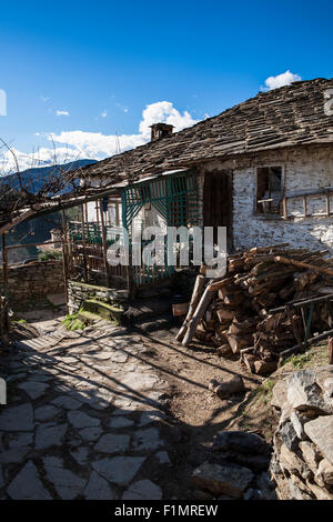 A small poor house with firewood stacked in front of it, Bashevo village, Ardino Municipality, Bulgaria, Rhodopi mountains Stock Photo