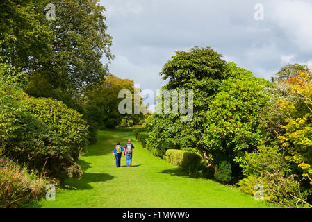 Middle-aged couple walking along the garden terrace, Muncaster Castle, West Cumbria, England UK Stock Photo
