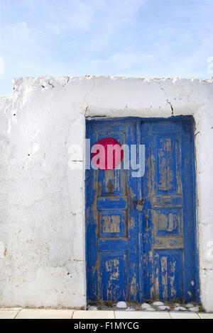 Old painted blue door on the whitewashed wall. Background. Typical for Greece. Stock Photo