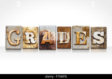 The word 'GRADES' written in rusty metal letterpress type isolated on a white background. Stock Photo