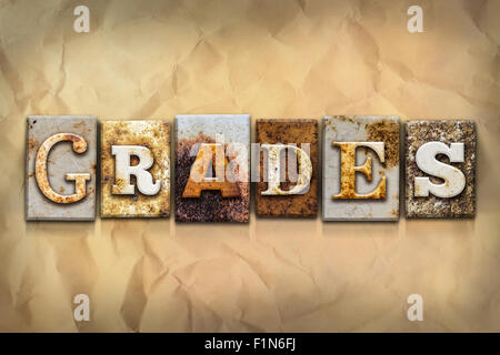 The word 'GRADES' written in rusty metal letterpress type on a crumbled aged paper background. Stock Photo