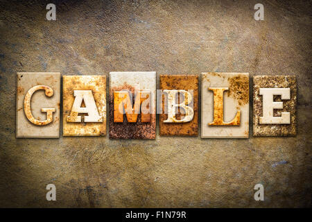 The word 'GAMBLE' written in rusty metal letterpress type on an old aged leather background. Stock Photo