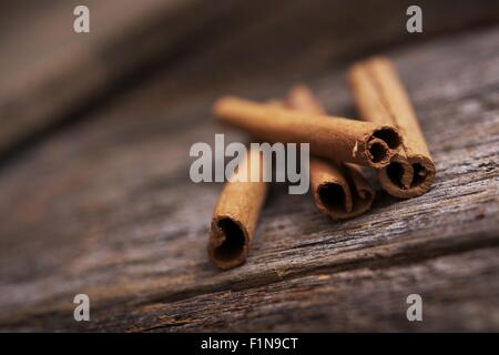 Raw Organic Cinnamon Sticks on Aged Wood Table. Stock Photo