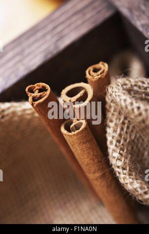 Fresh Raw Cinnamon Sticks in Wooden Crate with Canvas. Cinnamon Sticks Closeup. Stock Photo