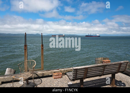 Astoria Oregon an old chair and a bench at pier's edge. Stock Photo