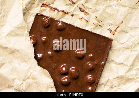 Melted chocolate bar with nuts in paper package Stock Photo