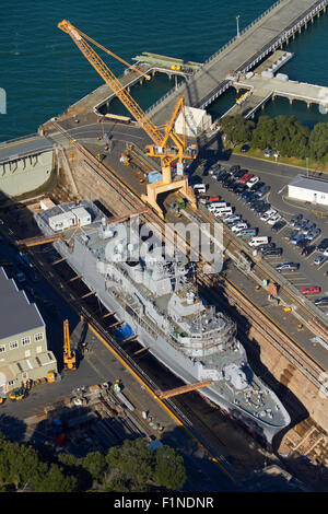 NZ Navy Frigate Te Mana in historic Calliope Dry Dock (built 1888), Devonport Naval Base, Auckland, New Zealand - aerial Stock Photo