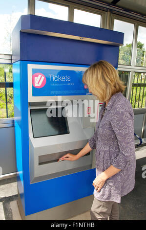 Woman buying rail ticket from a ticket machine at a station, UK Stock ...
