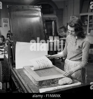 Historical, 1950s, picture shows a female worker using traditional methods to produce a print. Stock Photo