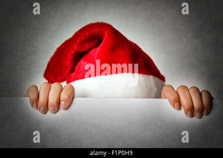 Image of Santa woman hiding behind a wall Stock Photo