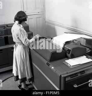 Historical, 1950s, female office worker or secretary using a large accounting or data printing machine. Stock Photo