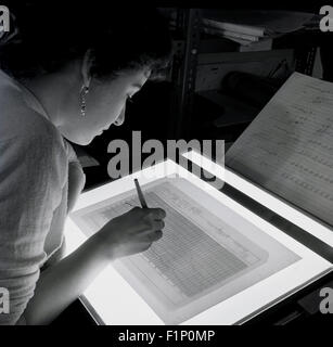 Historical, 1950s, female worker using a light-box to produce a graph on paper. Stock Photo