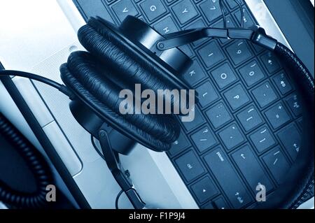 Digital Music Composer Theme. Modern Laptop Computer and Large Professional Headphones. Digital Music Composer Workstation. Tech Stock Photo