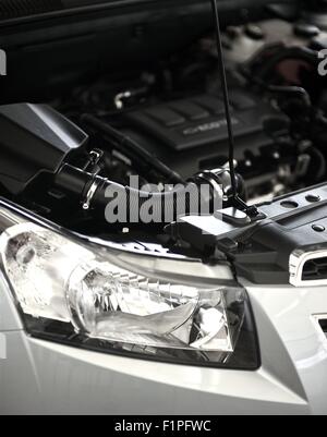 Open Car Hood - Modern Vehicle Engine. Front Part of Vehicle with Headlight. Air Filter. Vertical Photo Stock Photo