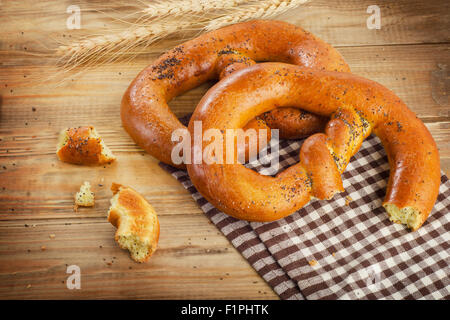 Two Freshly baked soft pretzels on a wooden table. Top view Stock Photo