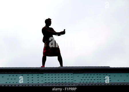 A man in silhouette takes photographs of the crowd from his smart phone, at the Notting Hill Carnival Stock Photo