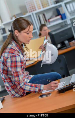 Architect sat drawing at her desk Stock Photo