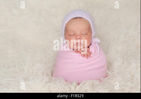 Sleeping Newborn Baby Girl Wrapped in a Pink Swaddle Stock Photo