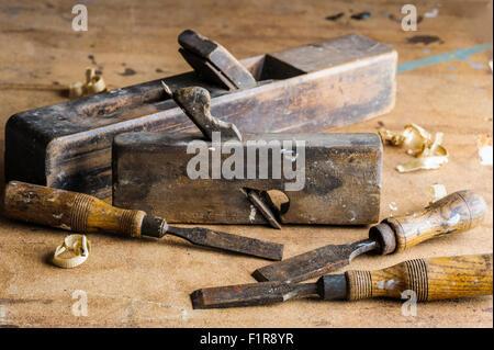 Two antique carpentry planes and three wooden handled chisels. Stock Photo