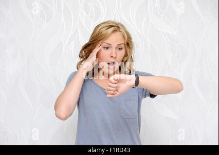 Young woman looking at her watch being late Stock Photo