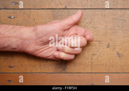 Old man's hand gesturing on wooden backdrop Stock Photo