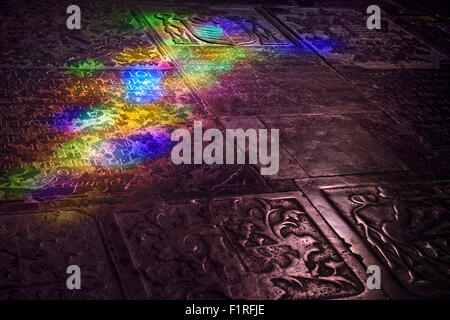 Stained glass colored light on carved tomb stone floor of Cordoba  our Lady of the Assumption Cathedral Spain previously a mosque Stock Photo