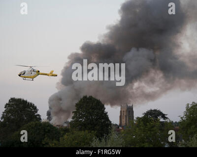 An air ambulance from the Essex and Herts air ambulance service hovers near a fire in the center of Sudbury, Suffolk, UK.. 2015. Stock Photo