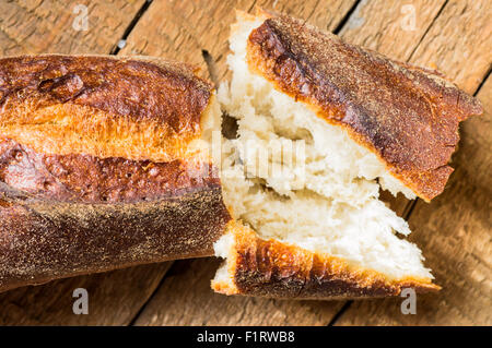 Break bread baguette on a table closeup top view Stock Photo