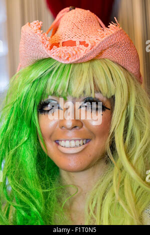 A female customer who has been transformed into a ganguro girl poses for pictures at the Ganguro Cafe & Bar in the Shibuya shopping area on September 4, 2015. Ganguro is an alternative Japanese fashion trend which started in the mid-1990s where young women, rebelling against the traditional idea of Japanese beauty, wore colorful make-up and clothes and had dark-skin. 10 Ganguro fashion girls work in the new bar, which offers original Ganguro Balls (fried takoyaki style sausage balls in black squid ink batter) on its menu. Ganguro Café & Bar also offers special services such as Ganguro make- Stock Photo