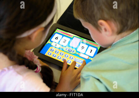 Primary school children using an iPad in the classroom Stock Photo