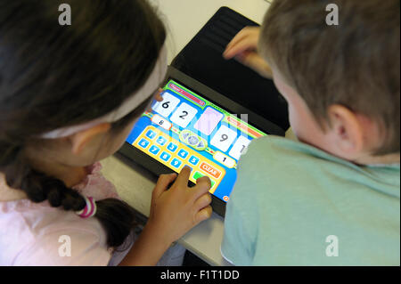 Primary school children using an iPad in the classroom Stock Photo