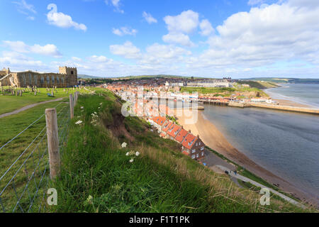St. Mary's Church and churchyard with view across Tate Hill Beach and town houses to West Cliff, Whitby, Yorkshire, England, UK Stock Photo