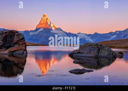 Pink sky at sunrise on the Matterhorn reflected in Stellisee, Zermatt, Canton of Valais, Pennine Alps, Swiss Alps, Switzerland Stock Photo