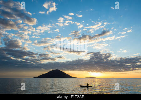 Silhouette of a man in a little fishing boat at sunset, Cape Malcear, Lake Malawi, Malawi, Africa Stock Photo