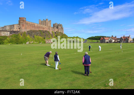 Playing croquet beneath Bamburgh Castle on a bright summer afternoon, Bamburgh, Northumberland, England, United Kingdom, Europe Stock Photo