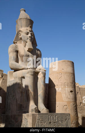 Ancient sitting statue of Ramses II in Luxor Temple lit up at night ...