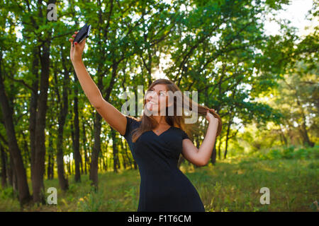 woman girl sELF outdoors photo makes self smiling blonde in a bl Stock Photo