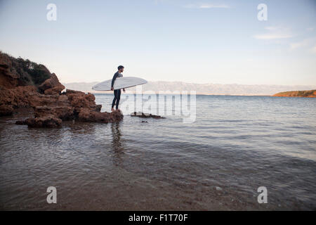 Surfer looking out on sea Stock Photo