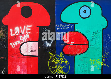 Red and green heads from the mural 'Some Heads' by Thierry Noir on the East Side Gallery on August 8, 2015 in Berlin, Germany.