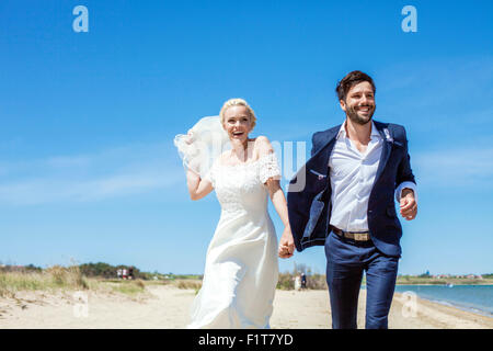 Bride and bridegroom on beach having fun Stock Photo