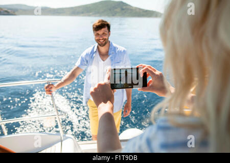 Young woman taking photo on sailboat, Adriatic Sea Stock Photo
