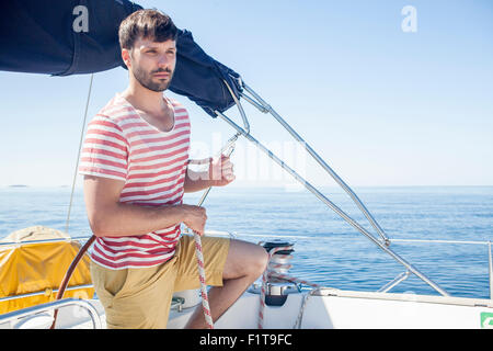 Young man overlooking sea on sailboat, Adriatic Sea Stock Photo