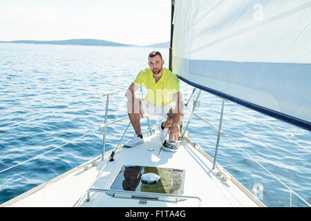 Man adjusting rigging on sailboat, Adriatic Sea Stock Photo