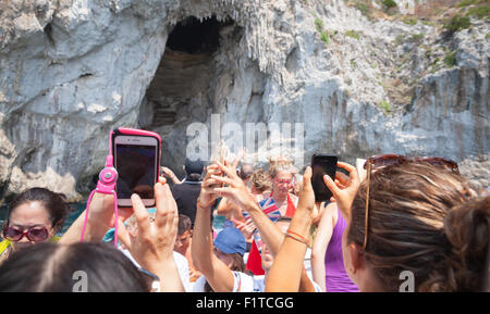 Capri, Italy - August 14, 2015: Tourists are taking photos on smart phones and tablet devices, boat trip around the Capri island Stock Photo