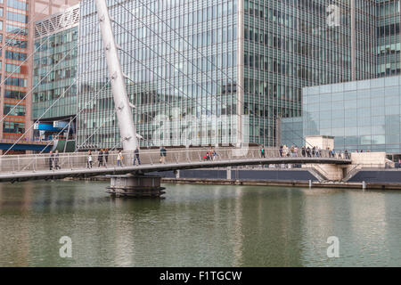 Office workers crossing Wilkinson bridge in London's Canary Wharf Stock Photo