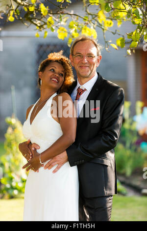 Mixed race couple in the garden on their wedding day. Stock Photo
